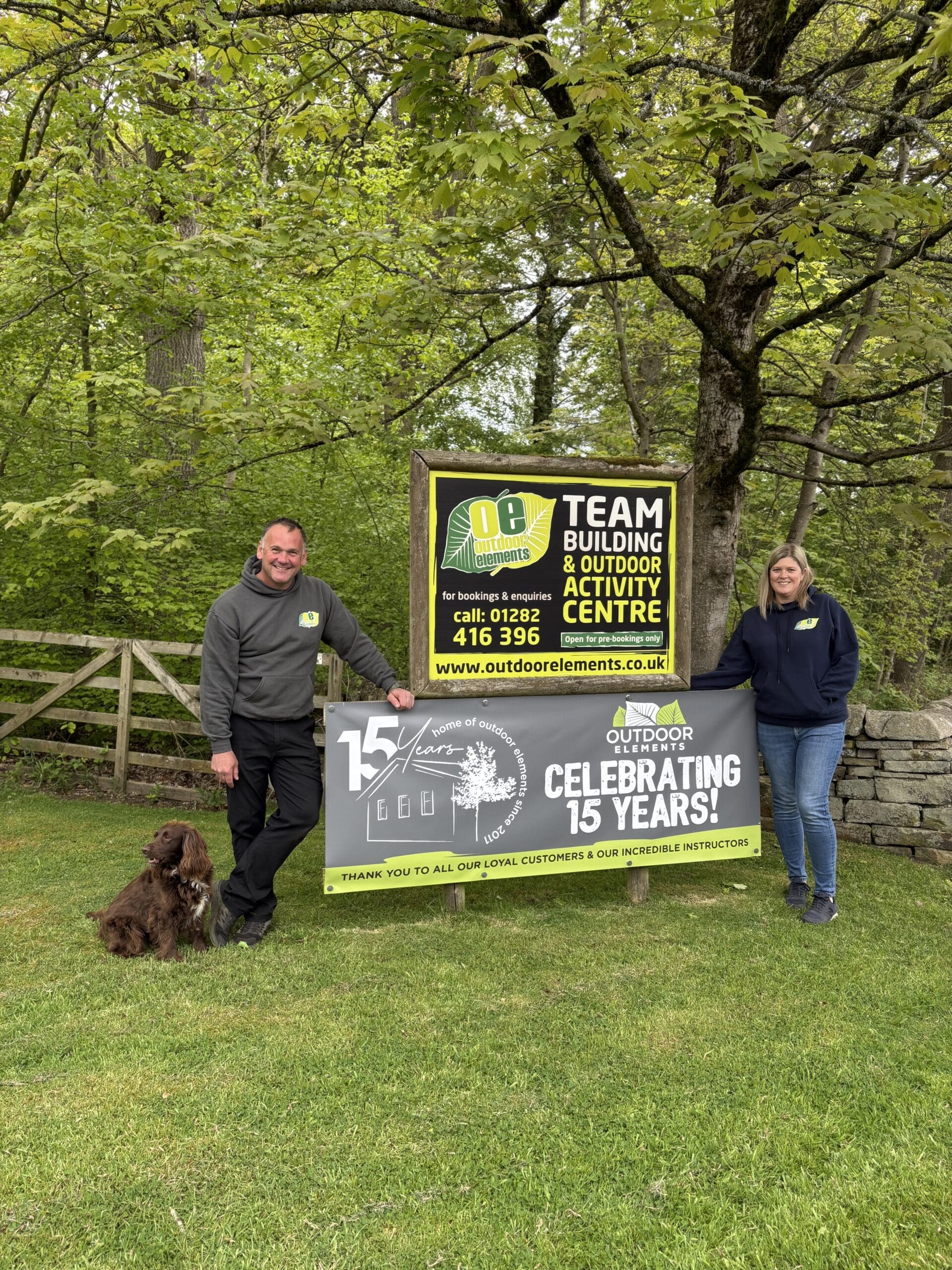 man and wpoman stood either sign of sign saying Celebrating 15years